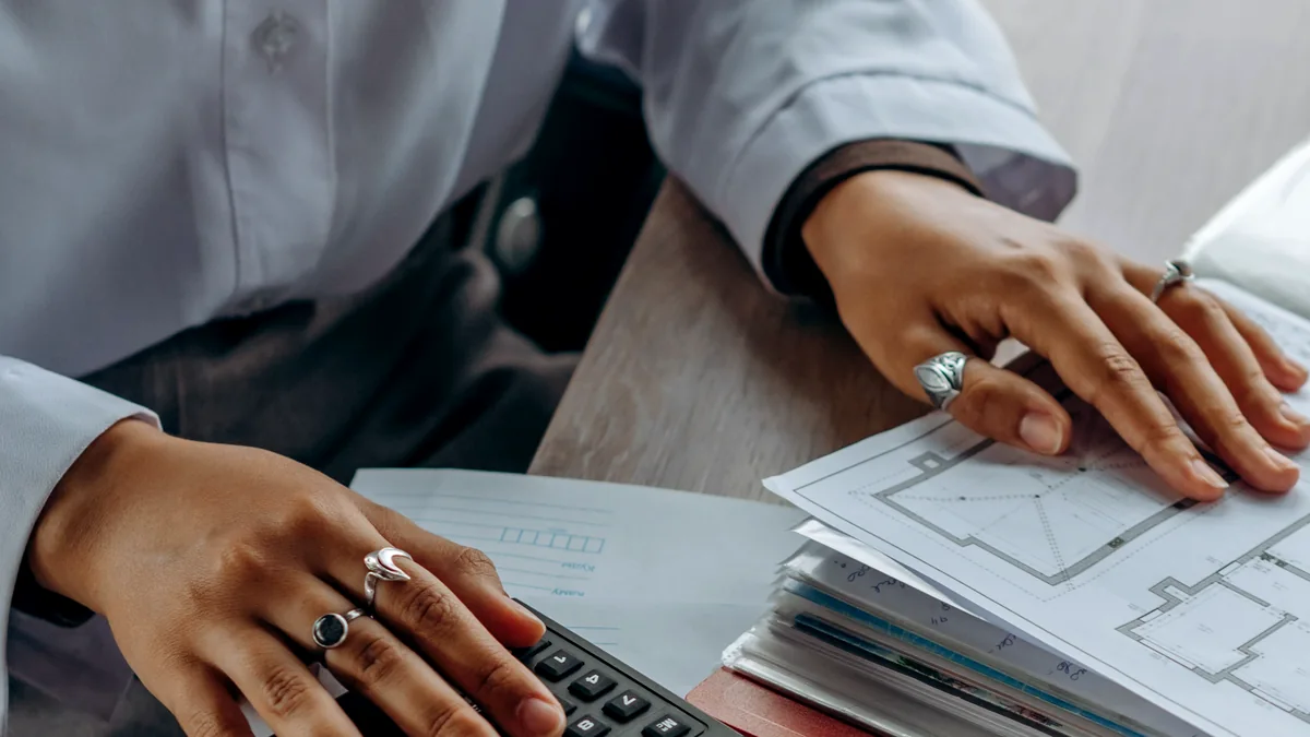 Accountant calculating costs with a calculator and documents