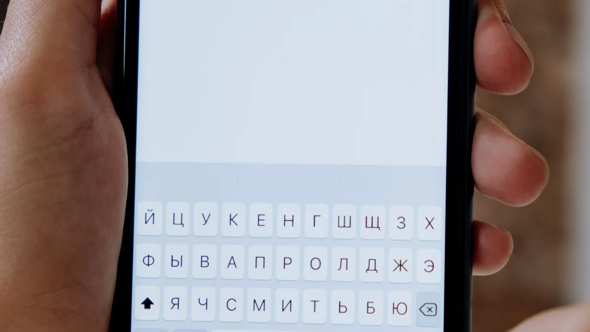 Hands holding a smartphone showing a search interface