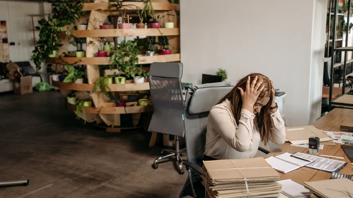 Stressed woman overwhelmed at her desk with paperwork
