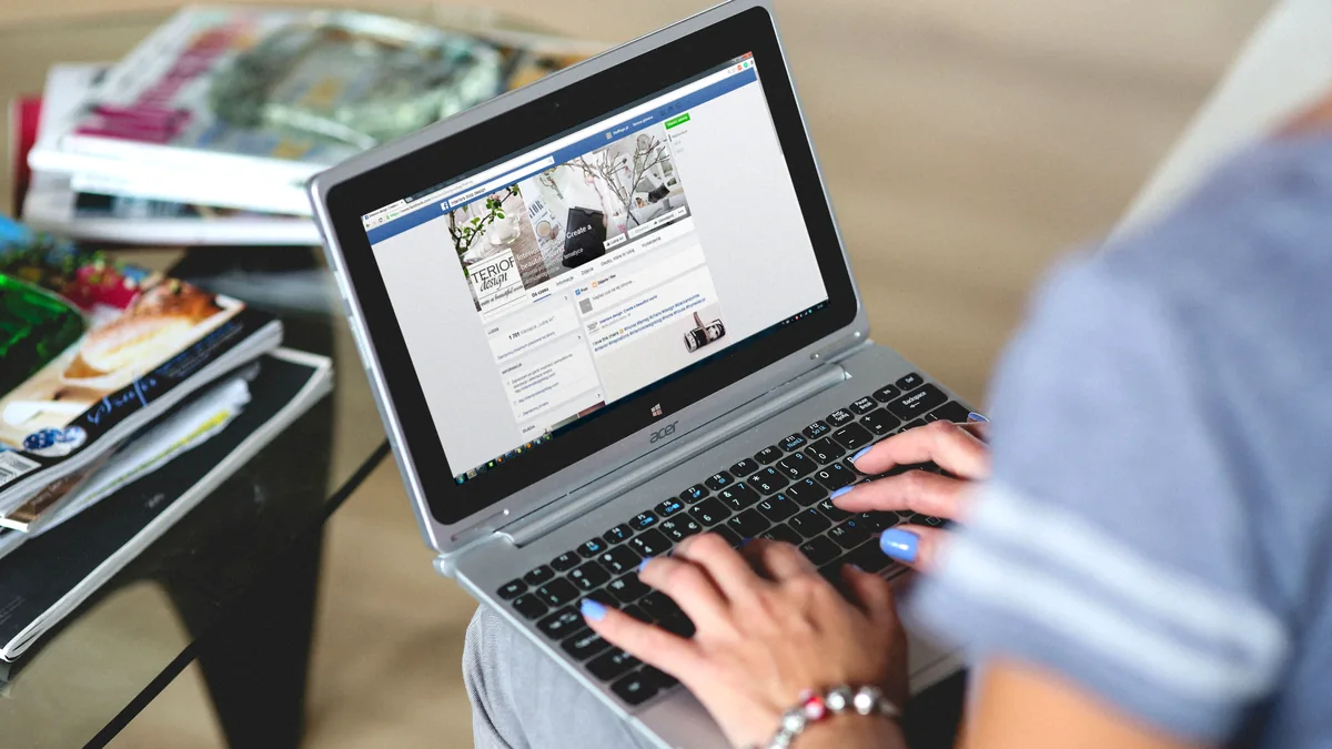 Woman typing on a laptop with a social media post open