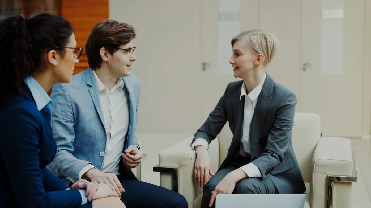 Three professionals talking during a business meeting